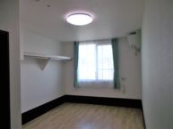 居室①　エアコン・カーテン・ナースコール・照明が備え付けです。壁にはレールがついており、お洋服を掛けておくことが出来ます。